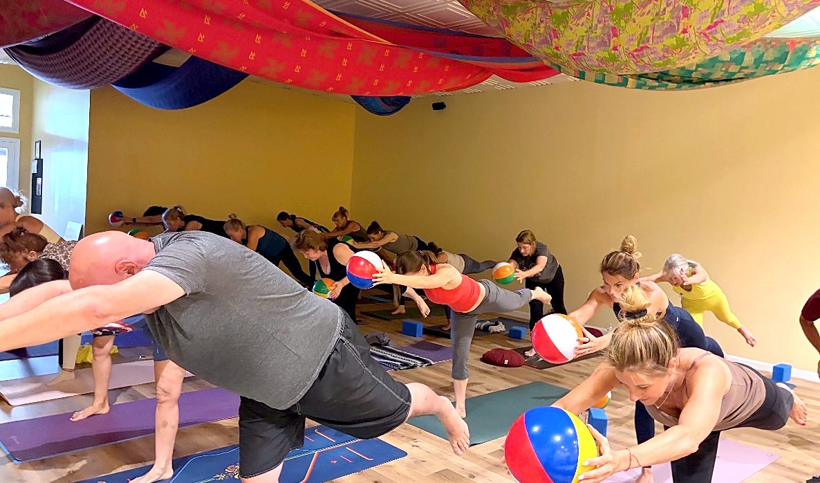 Students balancing on one leg in a flow class